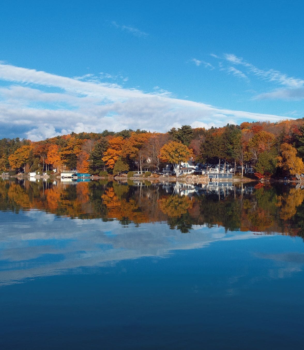 Autumn colors reflecting on the calm waters of Walloon Lake during fall.