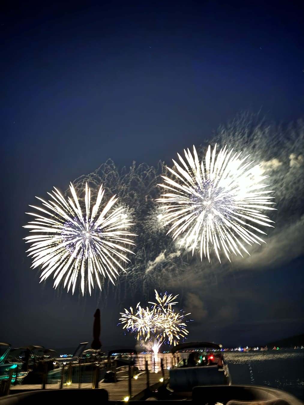 Fireworks lighting up the night sky over Walloon Lake with guests watching from the docks.